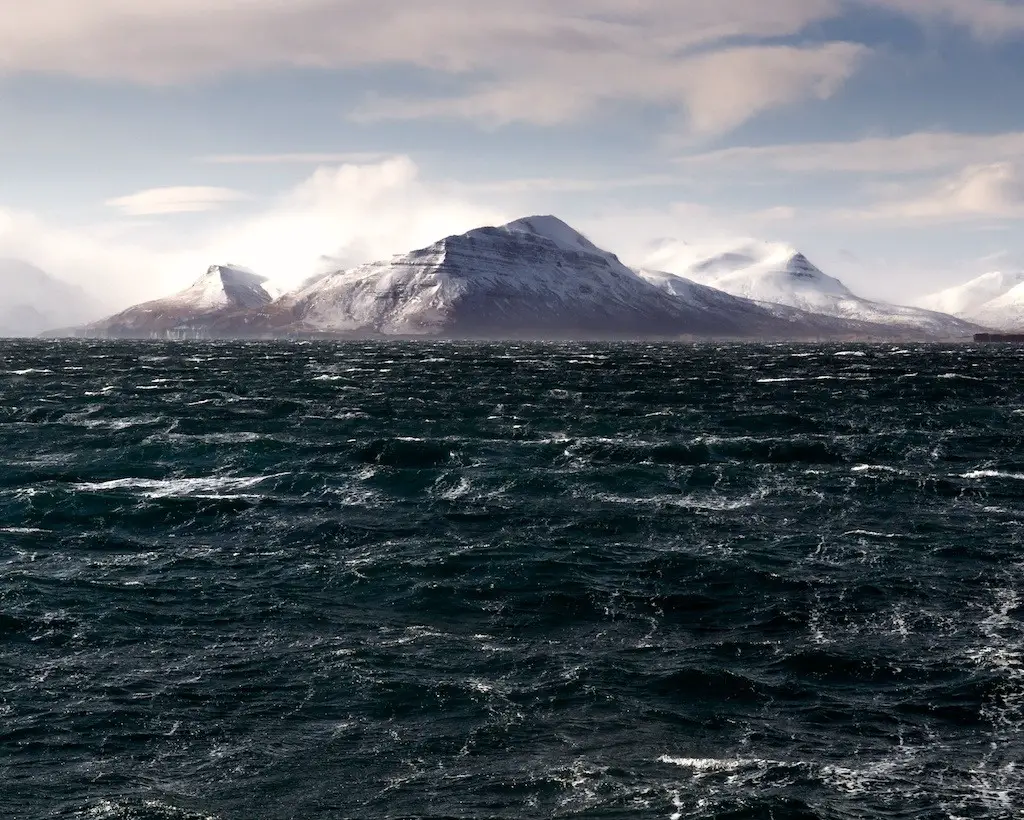 By Dan Brazelton This was taken from the deck of an ocean going tug hiding from 100 knot winds behind the island you can see. In the shelter, it was only 50 knots. And -50 degrees. I could only stand for a couple of seconds before the cold was too much and the lense was too wet. Then I took some time to warm up and try again. This was the best shot.